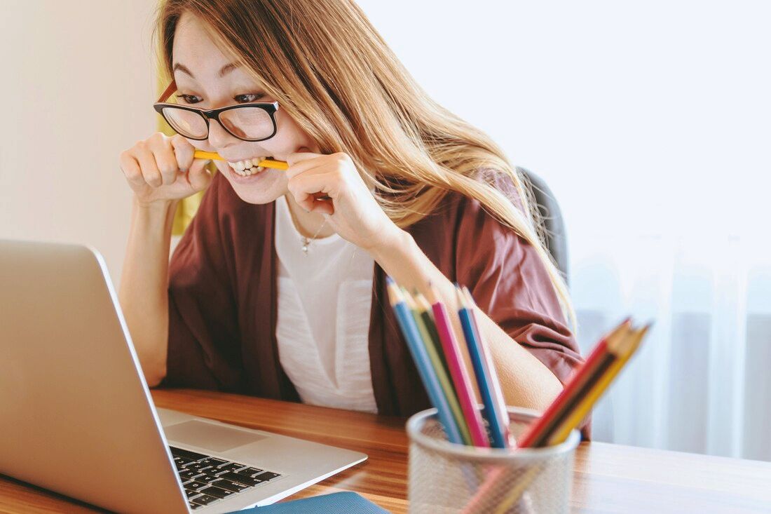 Female biting pencil looking at laptop worried | Counseling and Therapy for Creative People Person Centered Counseling and VIP Therapy for Creative People in Maryland Cindy Cisneros LCPC